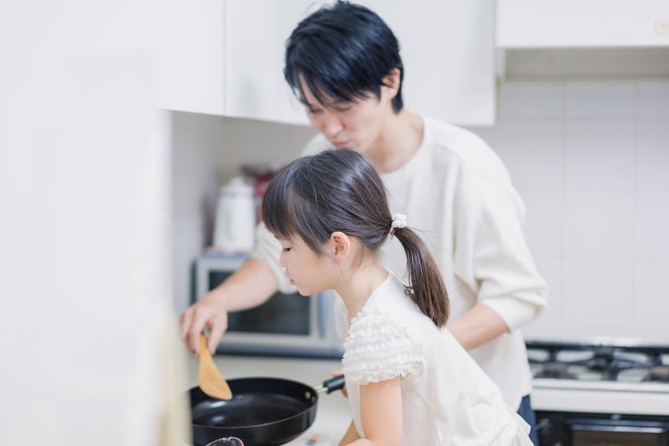 一个小女孩和她爸爸一起做饭图片下载