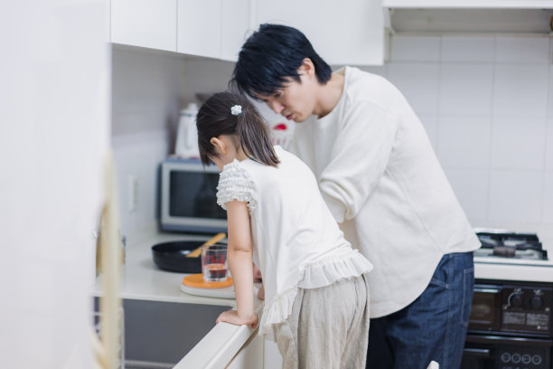 一个小女孩和她爸爸一起做饭图片下载