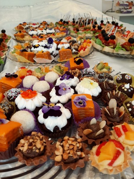 在一家大饭店，宴会桌上有纸杯蛋糕、松饼和饼干。图片下载