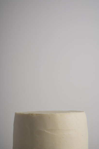 在一个没有装饰的白色糖衣蛋糕上，在一个浅色的背景上图片下载