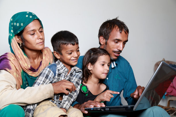 印度家庭在家里一起使用笔记本电脑图片下载