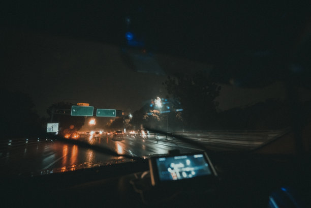 汽车的观点，驾驶在夜间的雨与雨刷打开在高速公路图片下载