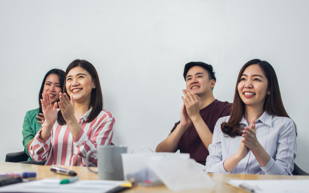 一群亚洲上班族穿着休闲的商务衬衫，坐在室内的研讨室里开会，做研讨会，掌声中洋溢着幸福和成功。图片下载