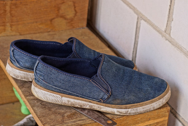 棕色的案板上放着两只棉布做的蓝鞋图片下载