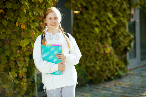 在城市户外穿着运动衫微笑的孩子的肖像图片下载