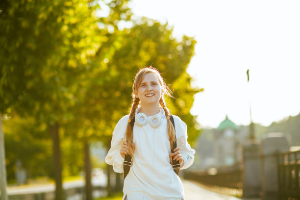 微笑时尚的小学生在城市户外上学图片下载