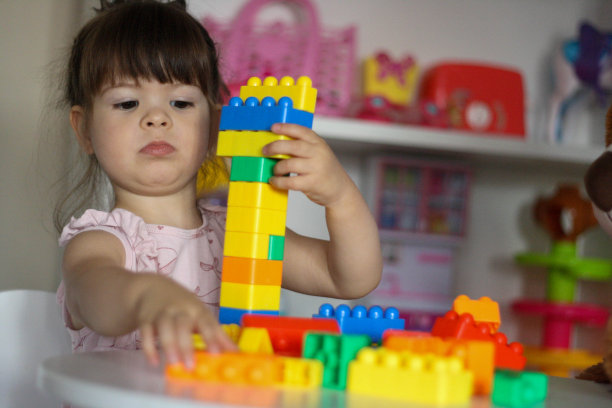 这个孩子用玩具积木搭了一座塔。图片下载