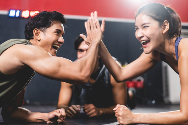 私人教练教练帮助年轻女性在健身房锻炼，运动训练锻炼健身，身体健康积极的运动生活方式，快乐的女孩健美与运动服图片下载