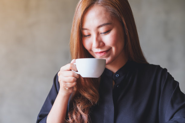 手捧热咖啡的年轻亚洲美女肖像图片下载