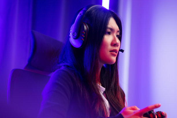 无聊和失败。年轻漂亮的亚洲女人玩游戏电脑电脑。女玩家戴着耳机玩游戏感到悲伤。失去和错过了成为冠军的机会图片下载