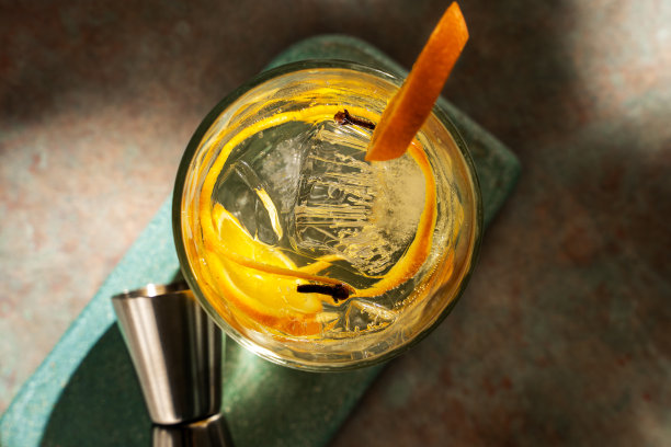 一杯杜松子酒加橘子片和冰块。深绿色背景图片下载