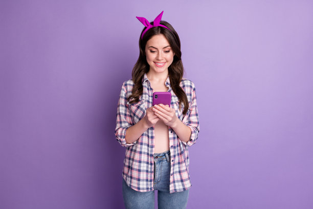 照片肖像的好女孩保持智能手机浏览互联网戴着头带方格衬衫孤立充满活力的紫色背景图片下载