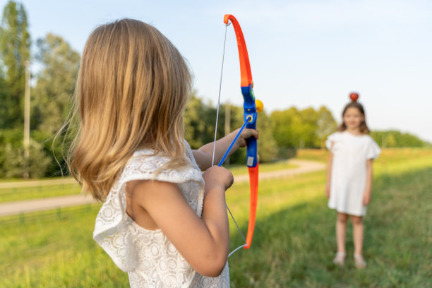 可爱的小女孩正在和她的妹妹玩玩具弓箭图片下载