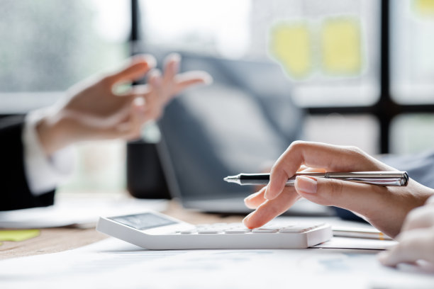 商人用计算器计算公司财务文件上的数字，他正在分析历史财务数据，计划如何发展公司。金融的概念。图片下载