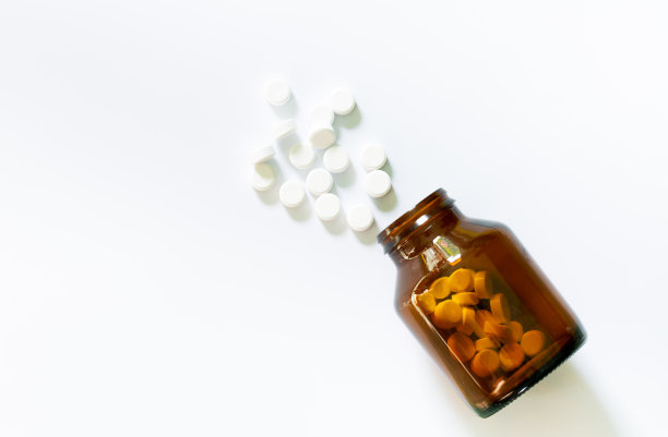 药片和药瓶在白色背景，草药药丸和玻璃罐孤立在白色背景。图片下载