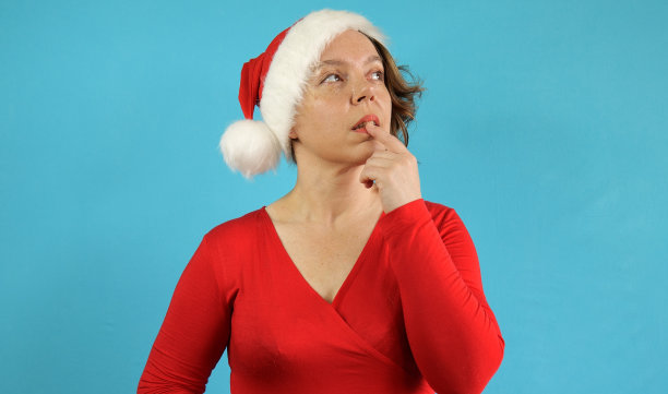 一个四十岁的忧郁的女人，蓝色背景下穿着红色夹克。女人的肖像图片下载