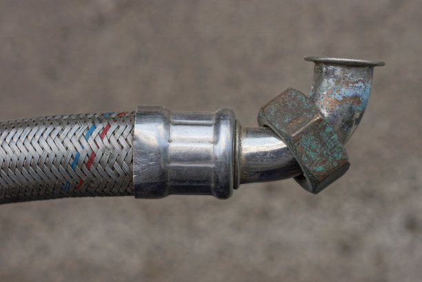 旧金属白色管道的一部分，有软管和管道螺母图片下载