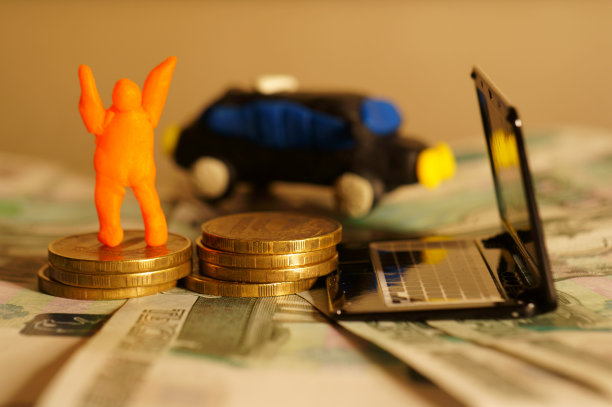 特写一堆硬币上一个快乐的小个子男人的形象。图片下载