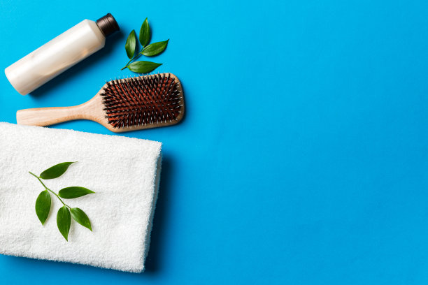 用于头发护理的化妆品，奶油和毛巾在彩色背景俯视图。平躺图片下载