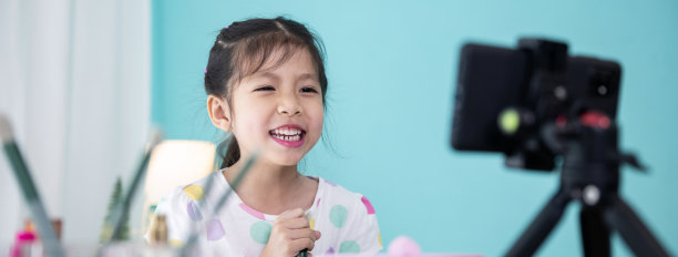 快乐的亚洲小女孩美容博主直播视频和教学使用化妆品的孩子。图片下载