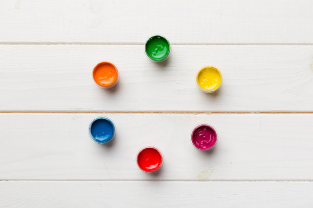 不同颜色的水粉罐在彩色的背景。爱好绘画。俯视图与空白的空间。工作场所的创造力。家庭教学概念图图片下载