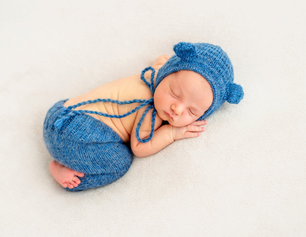 可爱的男孩戴着蓝色帽子睡觉图片下载