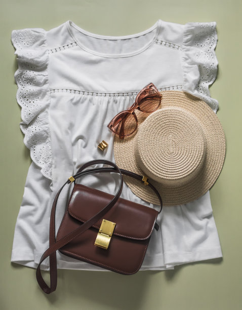 浪漫的蕾丝上衣，草帽，斜挎包-绿色背景的女装。俯视图图片下载