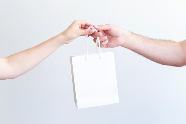 白色工艺包在一个男人和一个女人的手特写图片下载