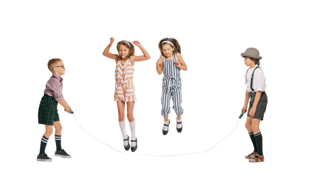 一群欢快的孩子在复古风格的夏装跳跃孤立在白色背景。艺术理念，友谊，希望，青春，时尚图片下载