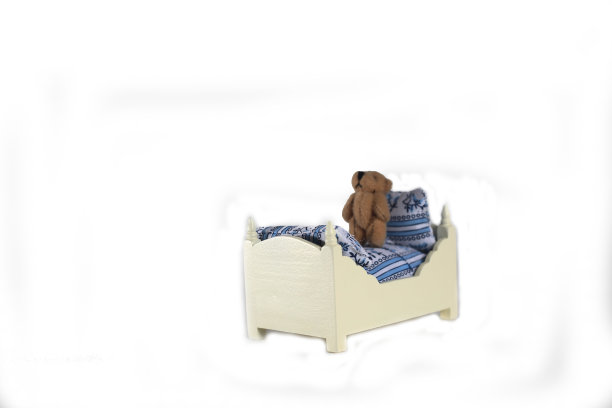 玩偶屋内部-白色背景上孤立的床上的泰迪熊。图像包含复制空间图片下载