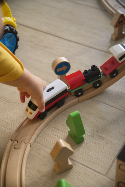 婴儿在轨道上玩木制玩具火车图片下载