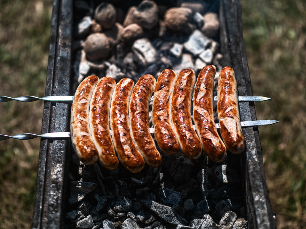 特写烤香肠在烤架上烤得焦黄。图片下载