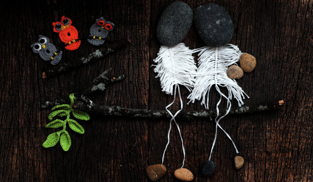 爱情概念背景下，夫妻俩骨架坐在树枝上，脑袋从鹅卵石上，幸福地坠入爱河图片下载