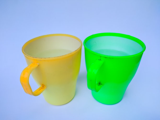 绿色和黄色的杯子，手柄由塑料材料制成图片下载