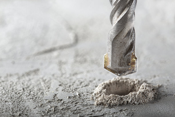 钻头用工业钻头在混凝土墙上打孔。建筑工程行业。图片下载