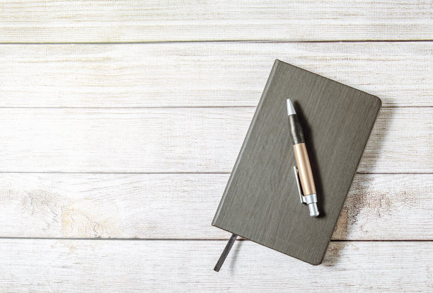 笔记本和钢笔放在木桌上图片下载