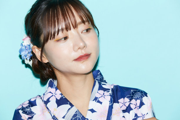 年轻女子肖像在yukata在蓝色背景图片下载