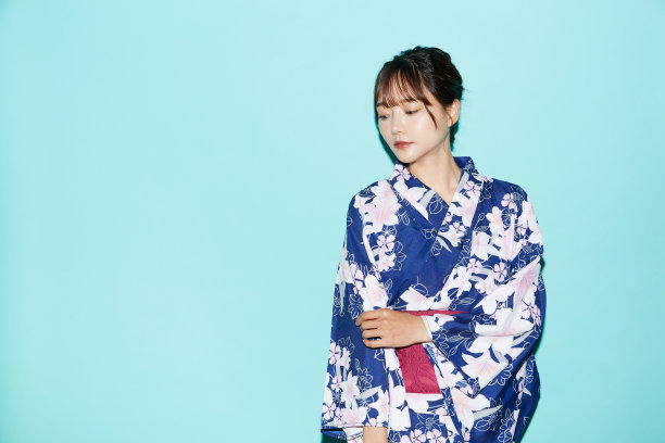 年轻女子肖像在yukata在蓝色背景图片下载