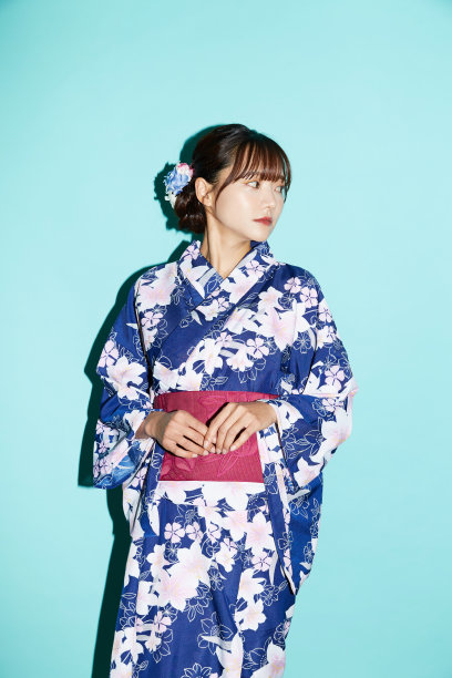 年轻女子肖像在yukata在蓝色背景图片下载