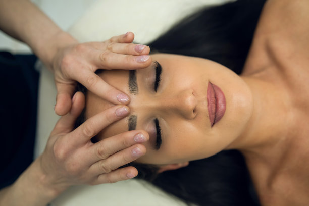 年轻女子在美容院做面部按摩图片下载