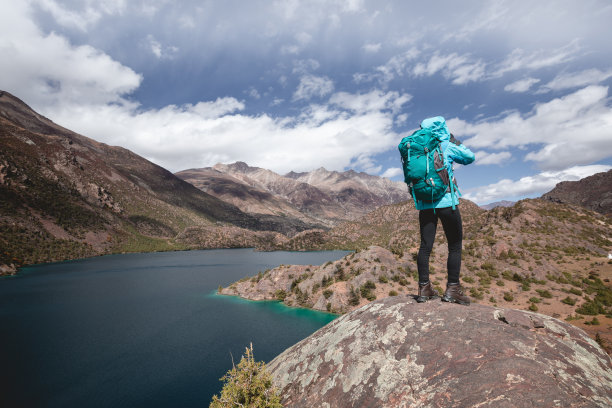 在美丽的冬季山区徒步旅行的女人图片下载