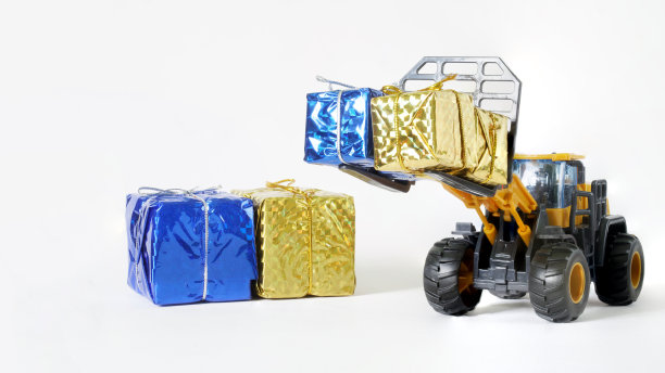 黄色和蓝色的礼品盒和一个玩具叉车。向乌克兰公民提供人道主义援助的概念。收集和分发礼物给乌克兰难民和儿童。本空间图片下载