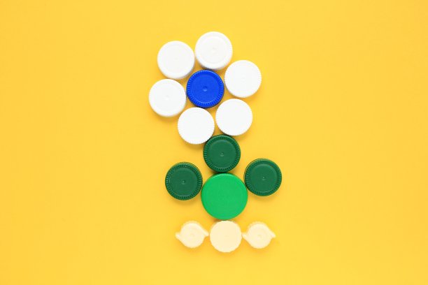 黄色背景的彩色塑料瓶盖花型马赛克装饰图片下载