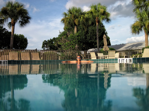 美丽的年轻女子在游泳池里放松图片下载