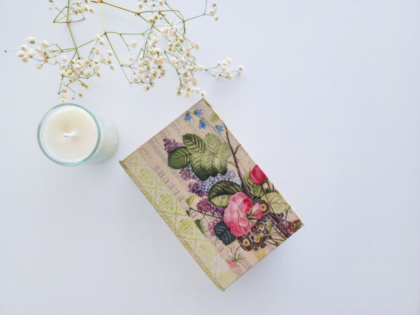书与花卉封面，蜡烛和白花在白色的背景图片下载