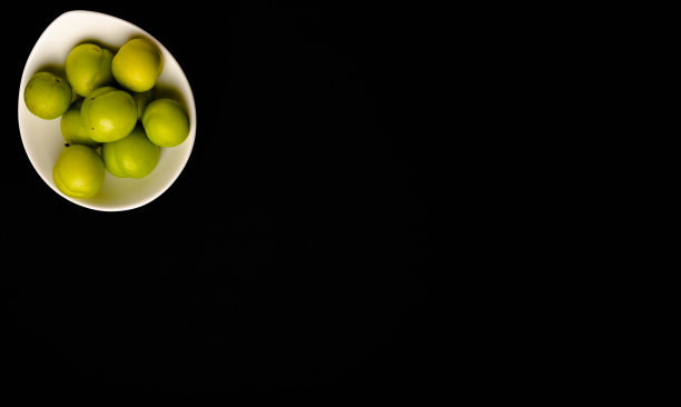 黑色背景上的青青的李子图片下载