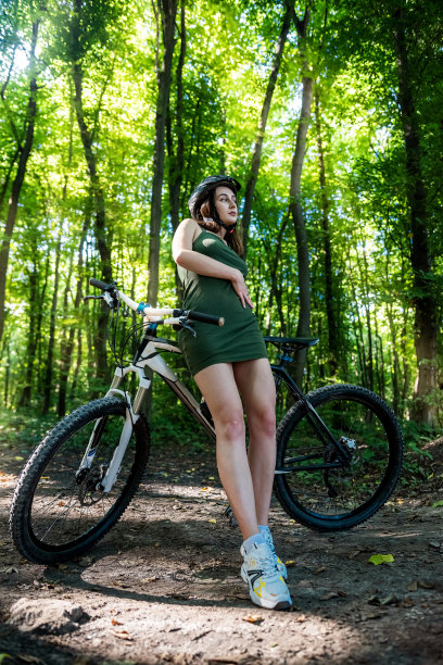 美丽的年轻苗条的女人骑着自行车在森林活动后休息图片下载