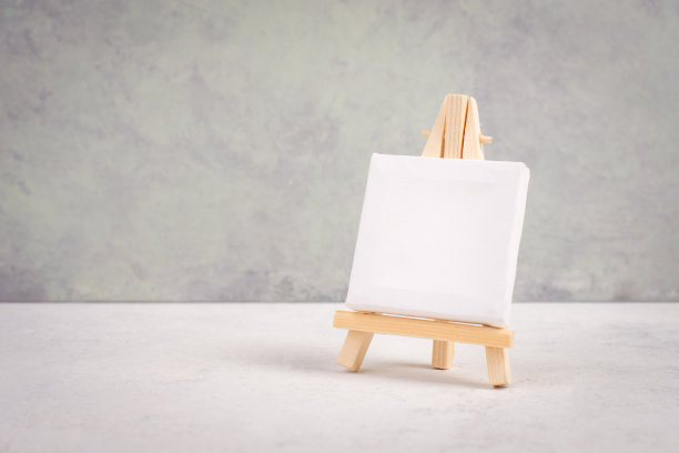 画架用白色空白画布在灰色有质感的背景前，添加画框和图片图片下载