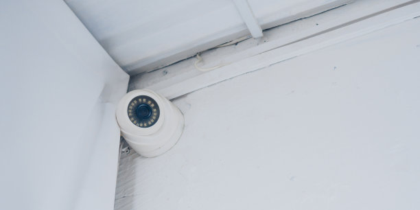 天花板下的白墙上有室内监控摄像头图片下载