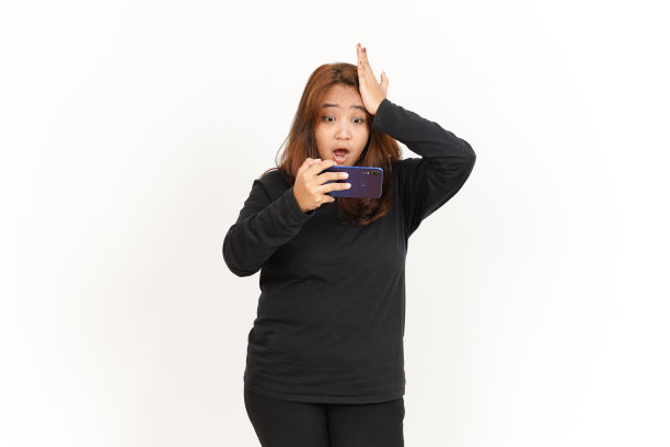 在智能手机上玩漂亮的亚洲女人穿黑色衬衫孤立在白色的手机游戏图片下载